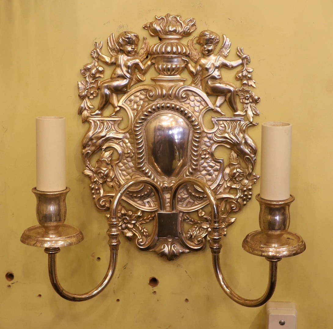 A pair of 17th century style silver plated wall lights with cherub and flower back plates and scroll and branches, height 30cm